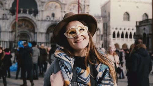 Portrait of Happy Woman with Long Hair Wearing a White Carnival Face Mask in Venice City Square