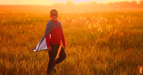 Boy Walks in Field at Sunrise with Cape