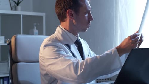 Professional medical doctor working in hospital office using computer technology.