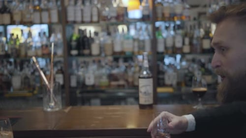 Unrecognizable Brunette Woman and Blond Bearded Man Sitting at the Bar