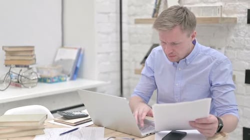 Homme d'affaires lisant des documents en travaillant