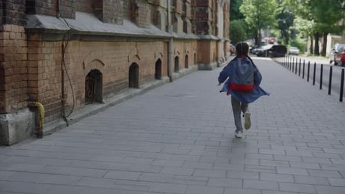Glückliches kleines Mädchen mit Rucksack und Notizen rennt zur Schule