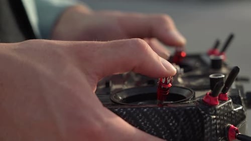 Man Operating Controls of a Drone Remote