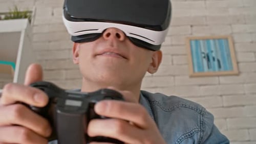 Young Man Playing VR Video Game at Home
