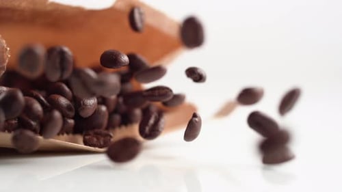 A bag of coffee beans falling onto a surface. Slow Motion.