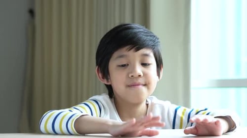 Young Boy Waving Hello, Smiling Indoors