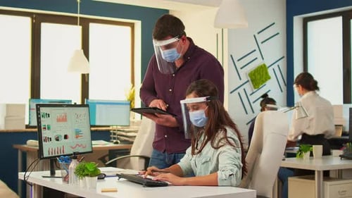 Coworkers Working at Desks with Face Shields