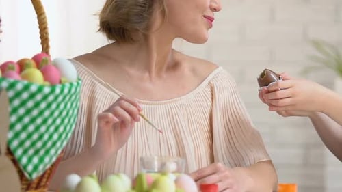 Well Mannered Girl Sharing Chocolate With Mother Who Painting Easter Egg, Family