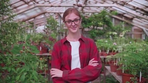 Smiling Woman Standing Inside a Tropical Greenhouse