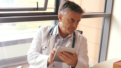 Doctor Using Tablet in Hospital Office