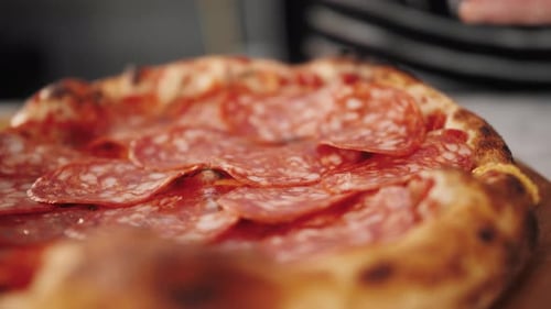 Pizza Preparation: Adding Salami Slices to Fresh Pizza