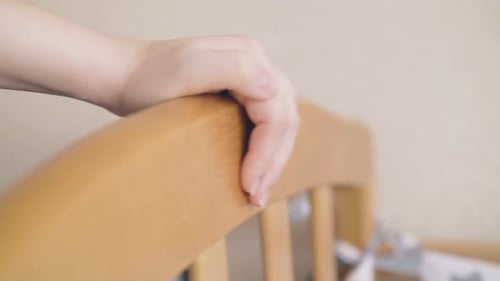 Hand on Baby Cot Contemplating