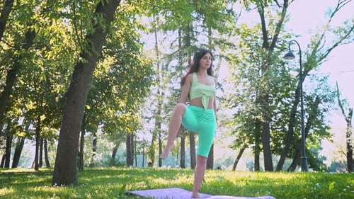 Beautiful Brunette Woman Sportswear Trains Yoga Asana Green Juicy Grass Purple Mat Barefoot Doing