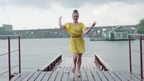 Cheerful Young Caucasian Girl Dancing on Pier Under Rain, Portrait of Positive Happy Woman in Yellow