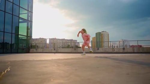 Energetic Child Dances on Urban Rooftop with Braids