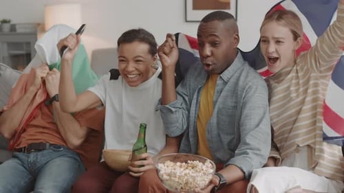 Friends Cheering While Watching Sports Game on TV