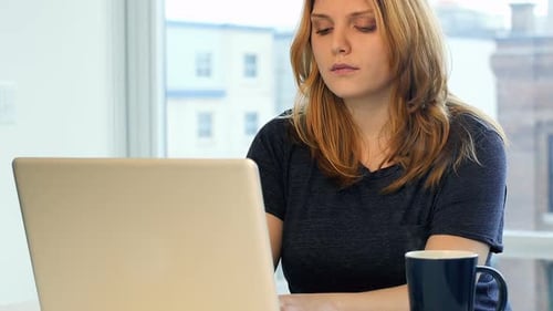 Young Woman Working at Laptop in Urban Apartment