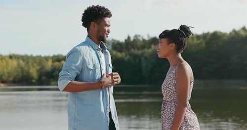 Young Couple Talking By a Lake On Sunny Day