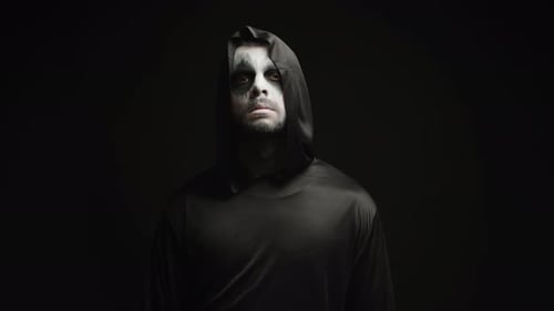 Man in Black Robe With Sinister Makeup Glaring