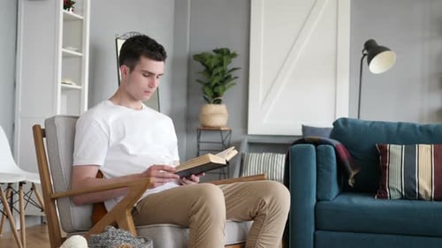 Young Man Reading a Book Indoors