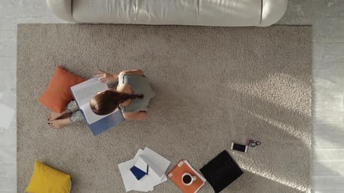Woman with Paperwork on the Carpet, Birds Eye View