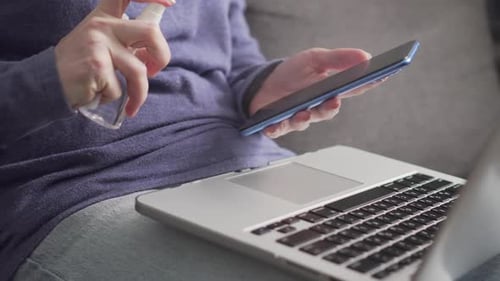 Adult Cleaning Phone and Working on Laptop