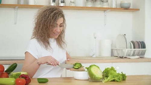 Woman Prepares Fresh Vegetable Salad in Kitchen