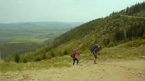 Hiking couple: two hikers (man and woman) walking together on the trail with backpacks