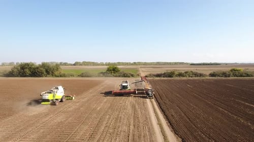 Harvesters Working in Open Farmland Field