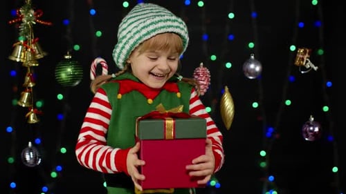 Happy Child Opens Christmas Gift With Candy Cane