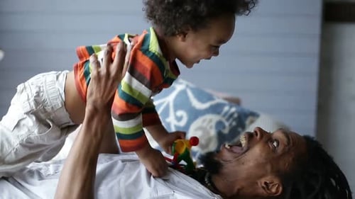 Dad and Child Playing Together on Bed