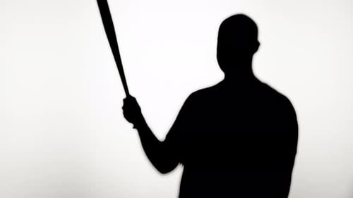 Man Silhouette Rotating Baseball Bat in Dark Shadow