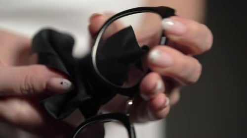 Woman Cleaning Stylish Black Framed Glasses