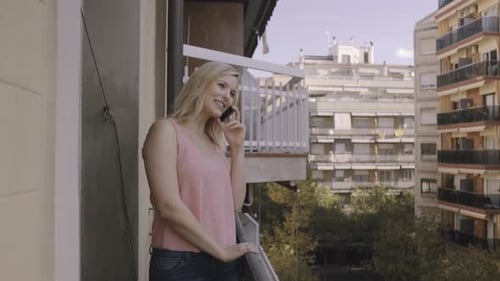 Woman Chatting on Phone on City Balcony