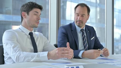 Businessmen Talking at a Table in Modern Office