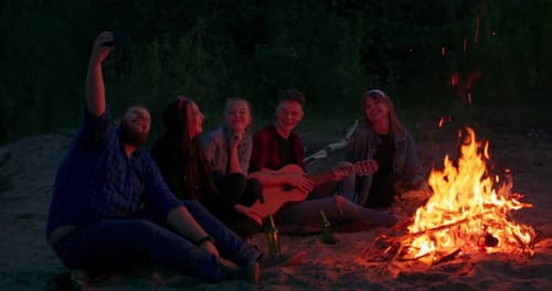Friends Enjoying Campfire at Beach at Night