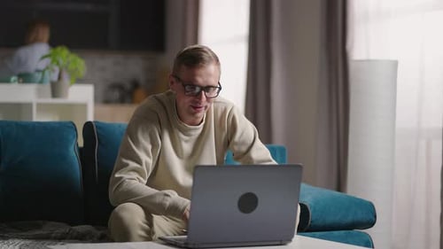 Young Adult Video Chatting on Laptop At Home