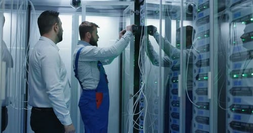 Two Men Performing Maintenance in a Data Center