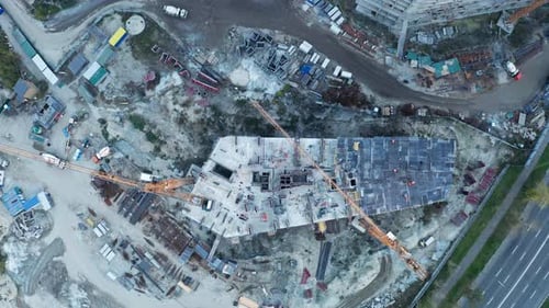Sitio de construcción con grúas al atardecer