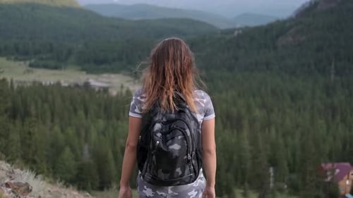 Attractive Girl Tourist on the Peak of the Mountain Raises Her Hands Up and Is Proud of Her Success