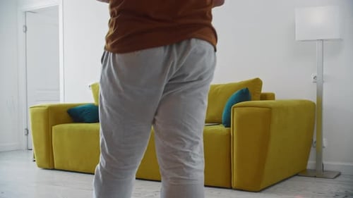 Man Sits on Couch and Opens Laptop