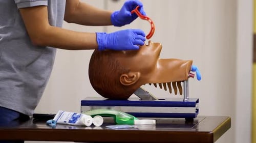 Medical Worker Inserts Airway into Training Dummy