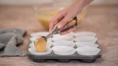 Young Woman Preparing Pumpkin Muffins at Home.
