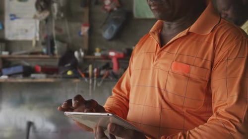 Afrikanischer Mann schaut bei der Arbeit auf Touchpad