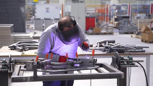 Man Welding Metal in Bright Industrial Workplace