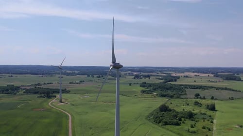 Aerial view of windmills farm for energy production on beautiful cloudy sky at highland. Wind power