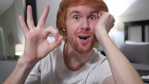 Okay Sign By Casually Sitting Redhead Man Close Up