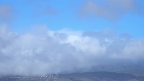Billowing Clouds over a Mountainous Landscape