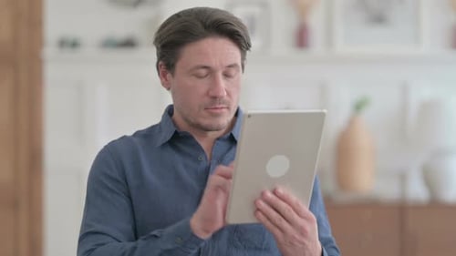 Portrait of Attractive Man using Tablet in Office