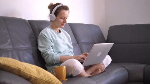 Woman Using Laptop at Home on Couch
